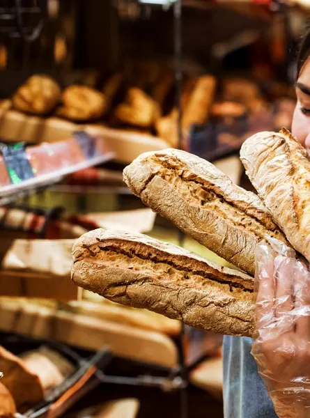 Femme sentant des baguettes de pain - Woman smelling bread